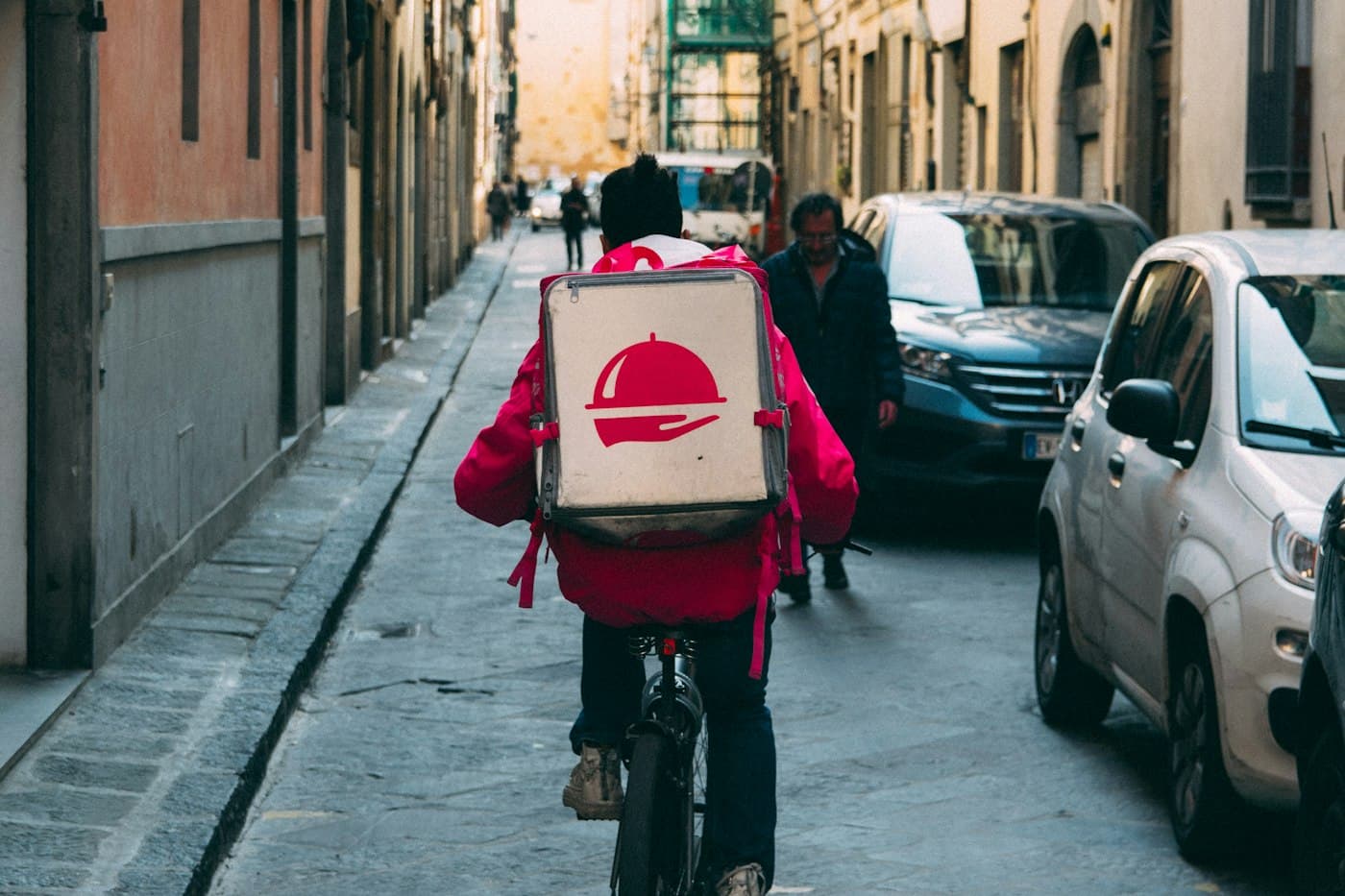Food delivery rider cycling through a city street
